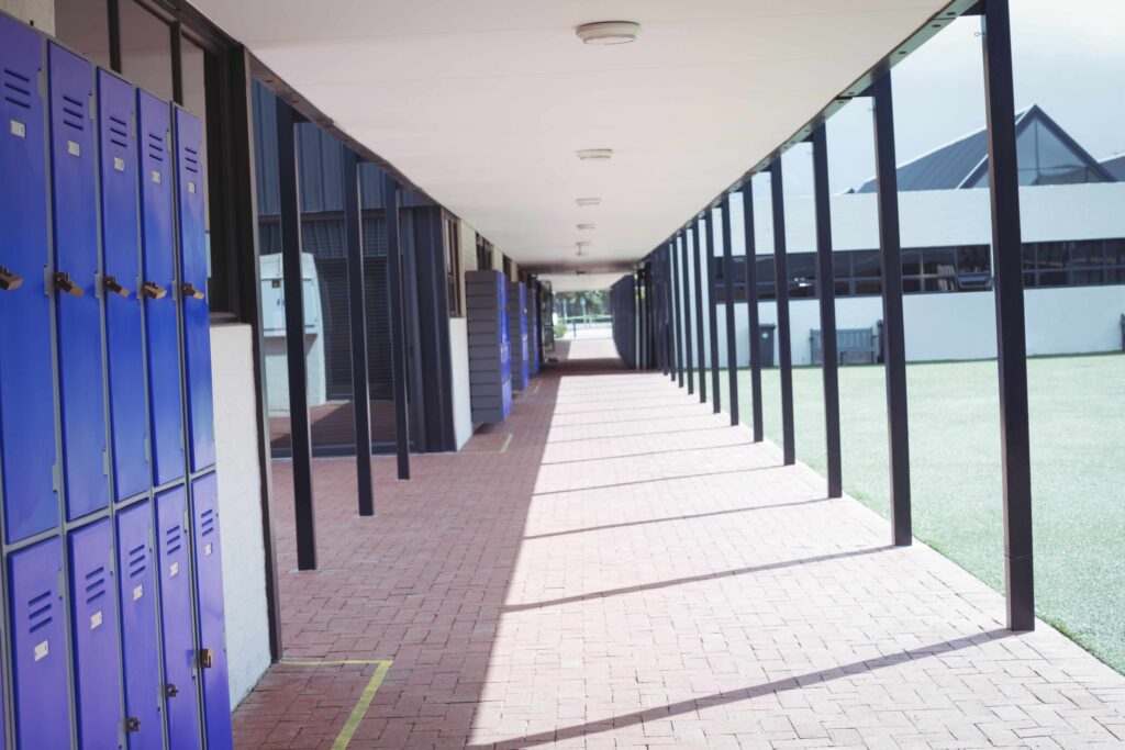 An empty hallway in a school setting, with lockers on the left.